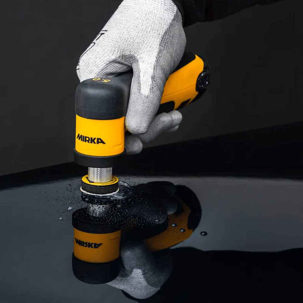 Professional tradie using a Mirka AROS-B cordless sander for automotive spot repairs