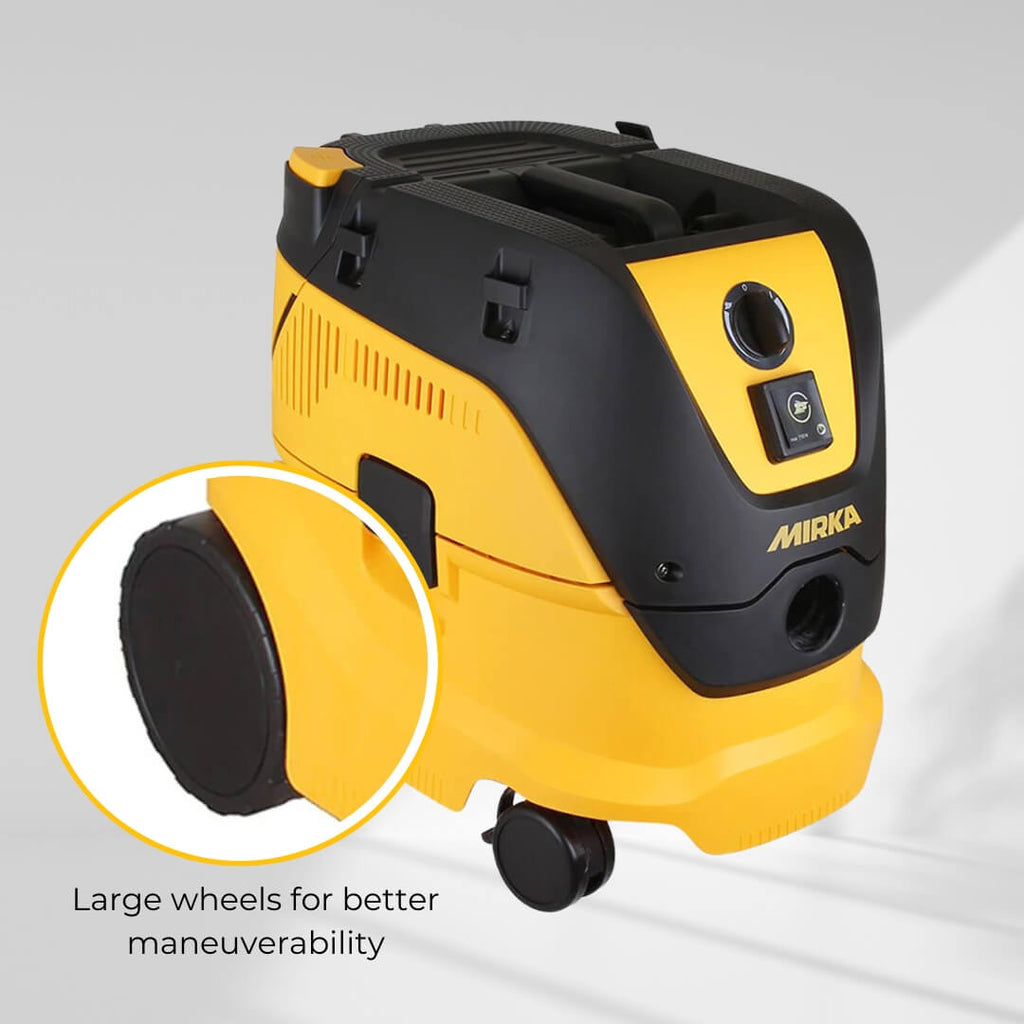 Large wheels on the Mirka 1230L dust extractor for easy maneuverability in the workshop