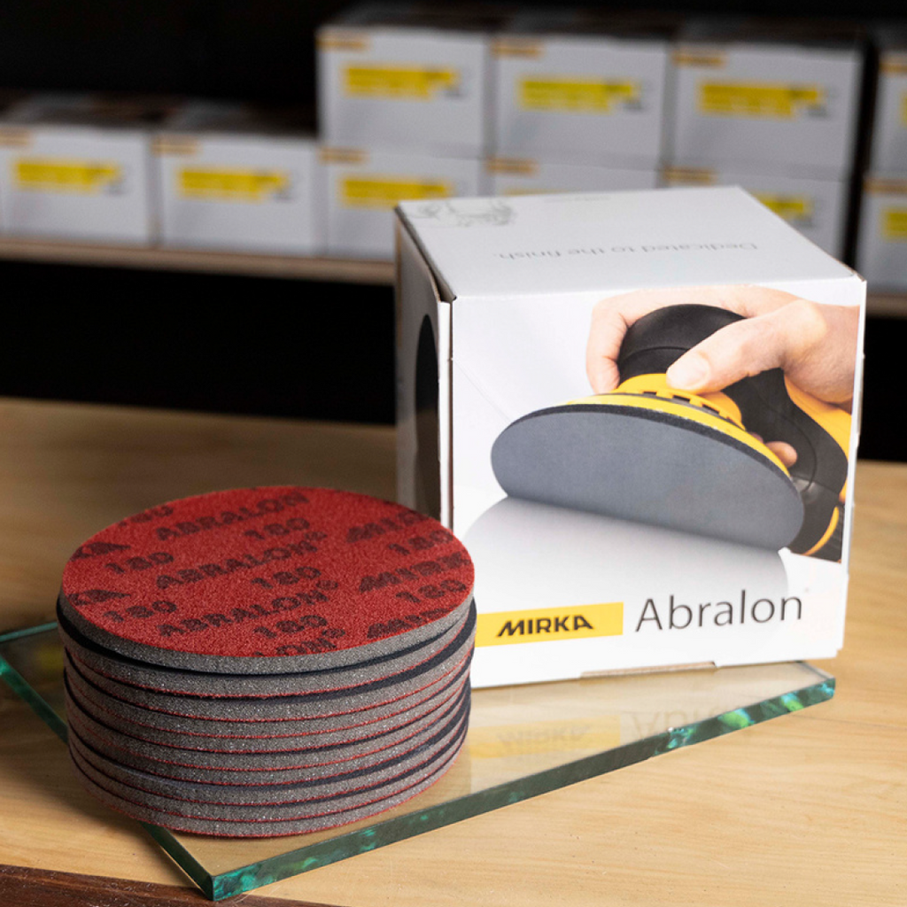 Stack of red Abralon foam discs next to a box for high-gloss timber finish refinement