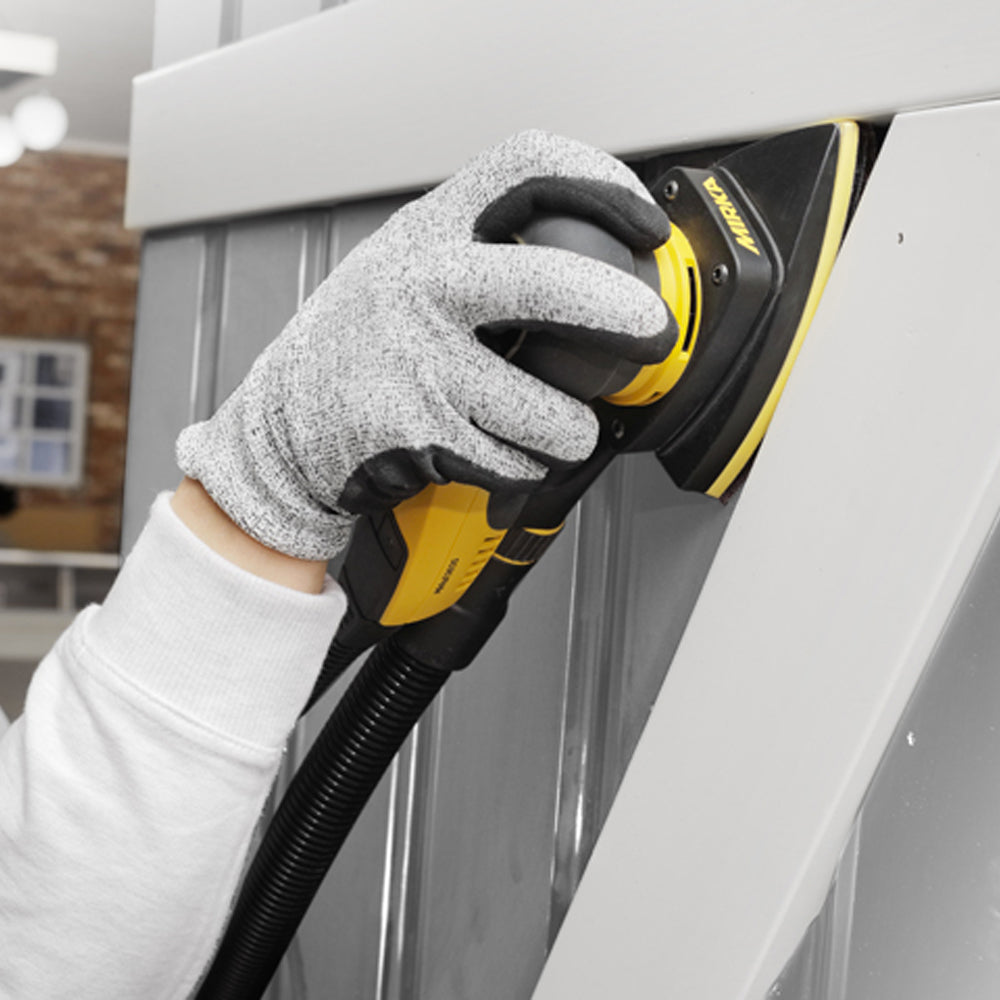 Tradie using a Mirka DEOS Delta sander to precisely sand tight corners on a grey panel