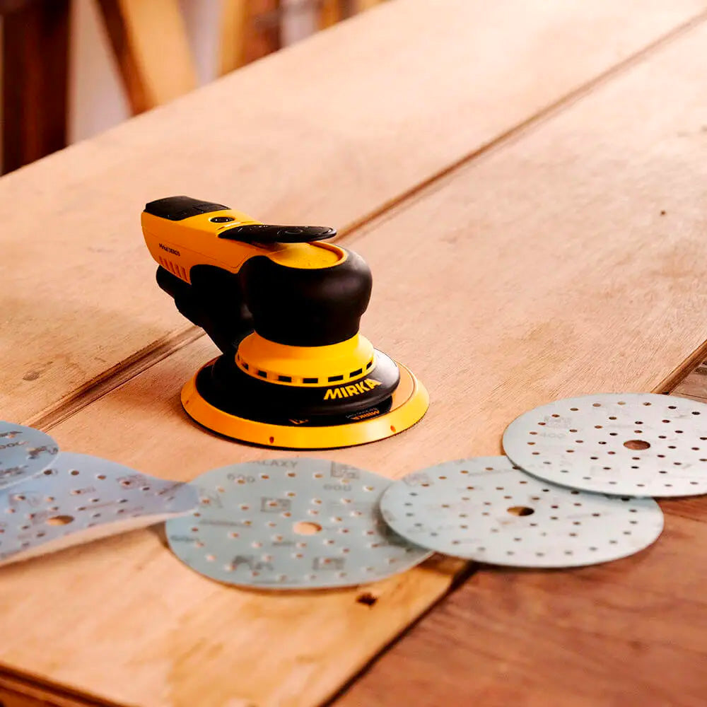 Mirka DEROS sander on a timber bench with a range of blue 150mm Galaxy Multifit discs