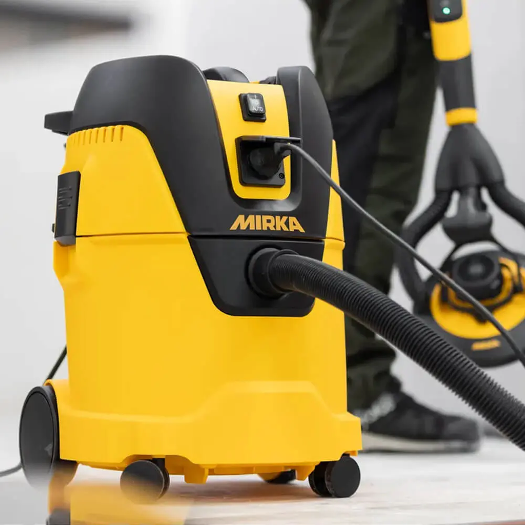 Mirka dust extractor connected to a power tool for dust-free sanding in the workshop