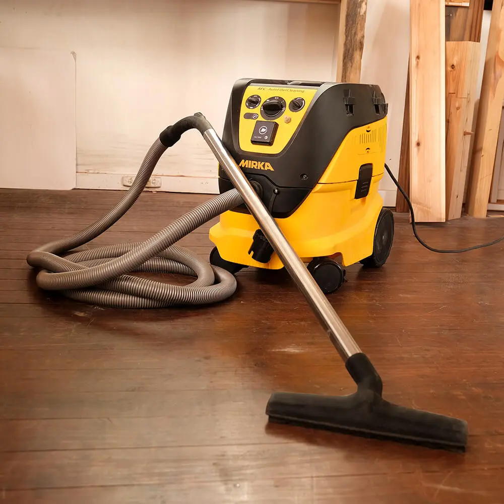 Professional Mirka clean-up kit being used to clear timber dust from a workshop floor