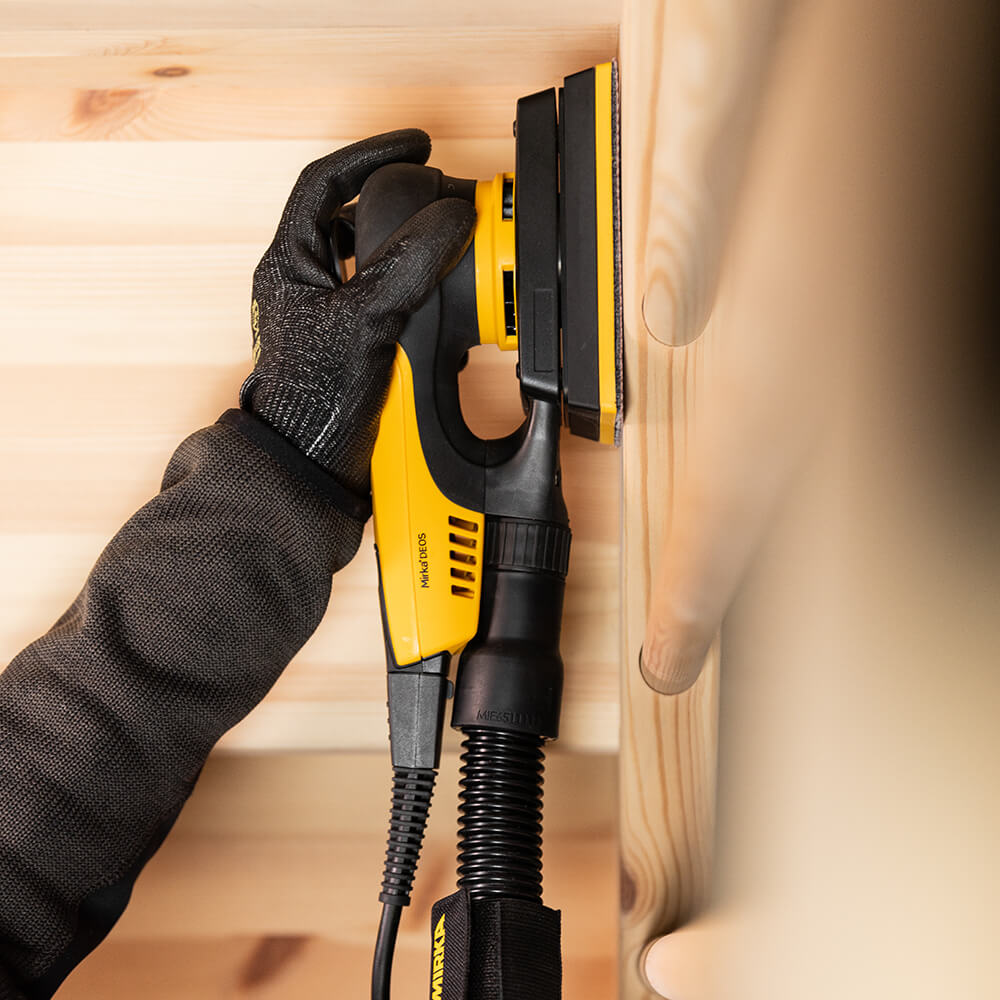 Professional tradie sanding a timber surface using the compact Mirka DEOS II