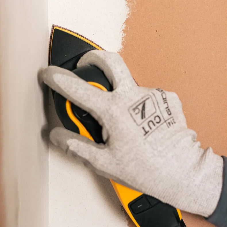 Tradie sanding internal corners of a plasterboard wall using the Mirka DEOS II Delta