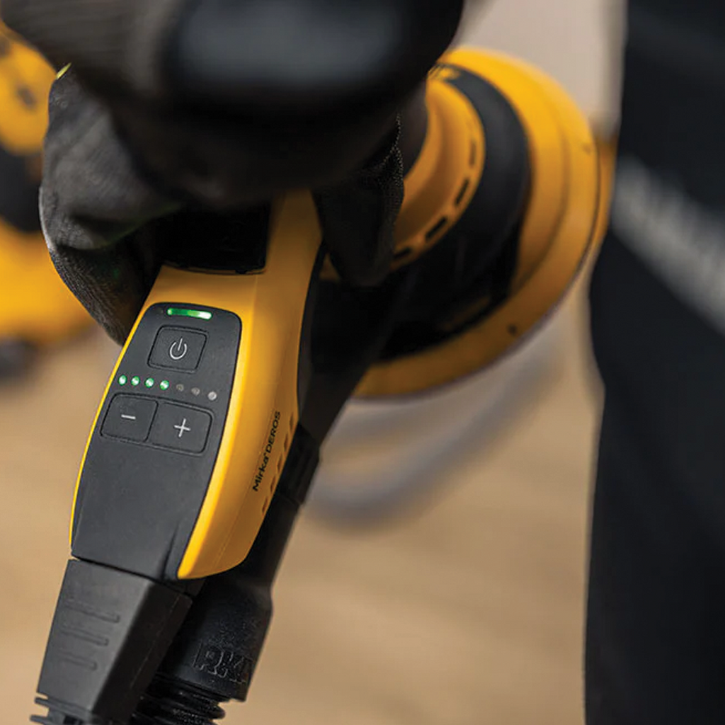 Detailed view of Mirka DEROS II speed control lever with green LED RPM status lights