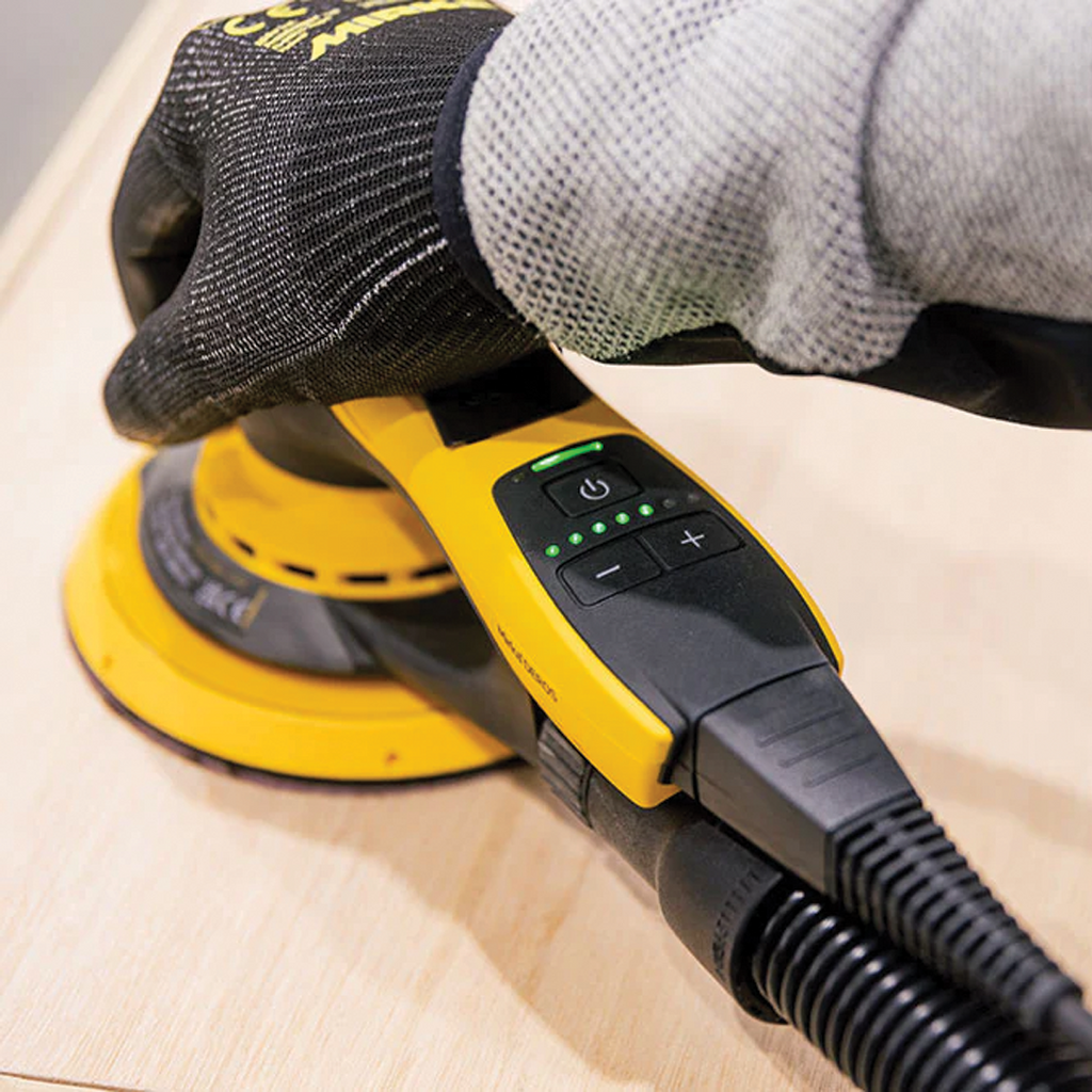 Professional woodworker using Mirka DEROS II to achieve a smooth finish on a timber panel