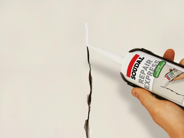 Precision repair of a wall crack using Soudal Repair Express Plaster in a caulking gun