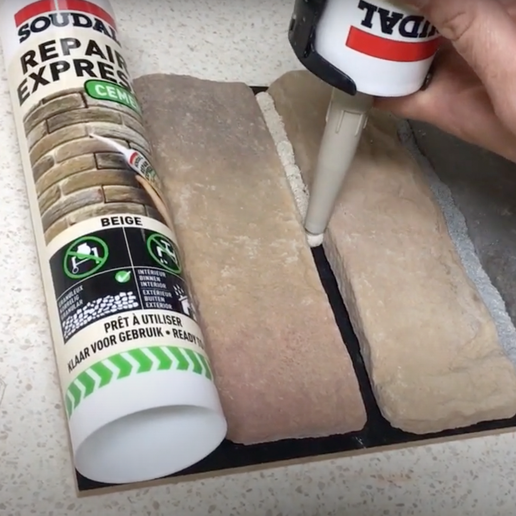 Applying Soudal Beige Repair Express Cement with a nozzle into a stone wall gap